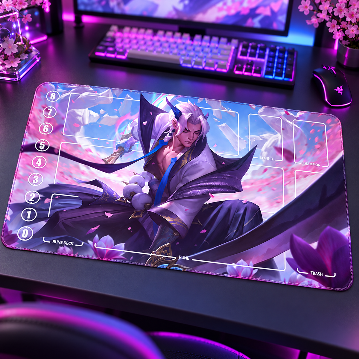 Spirit Blossom Aphelios Riftbound TCG playmat — angled RGB gaming-desk view; accessories are props