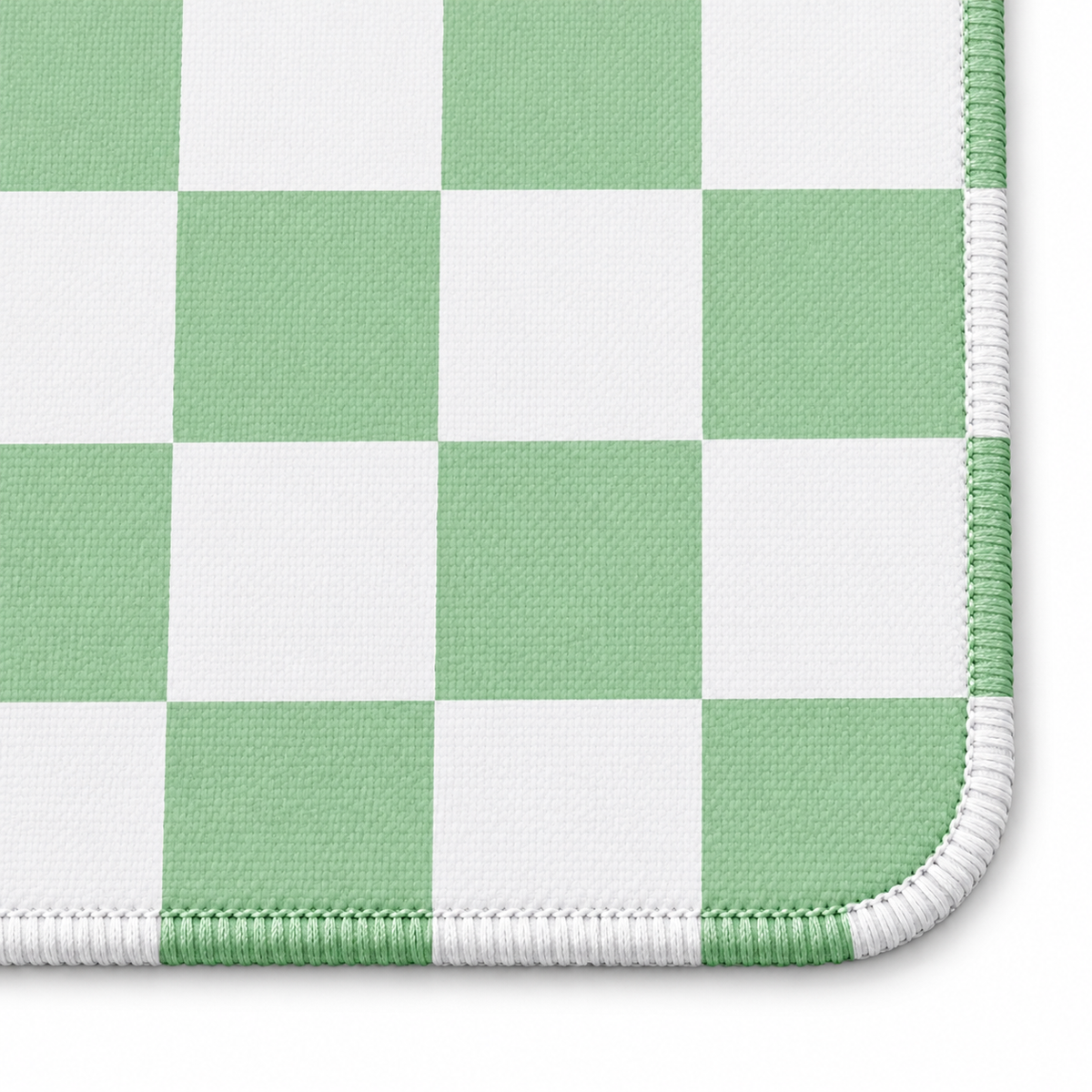Checker green mahjong mat corner close-up with stitching that follows each colored and white square