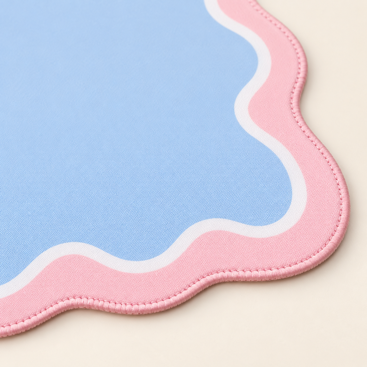 Pink artwork-matching stitching on the Cotton Candy Scallop mat