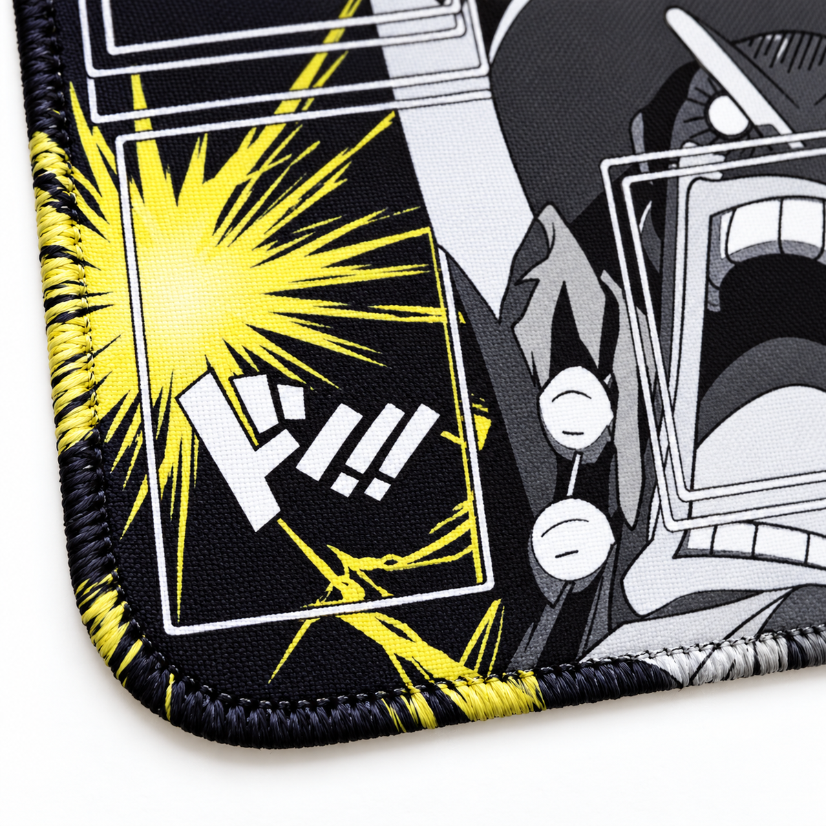 Close-up of black, yellow and white artwork-colored stitched corner on Shock Trio One Piece playmat