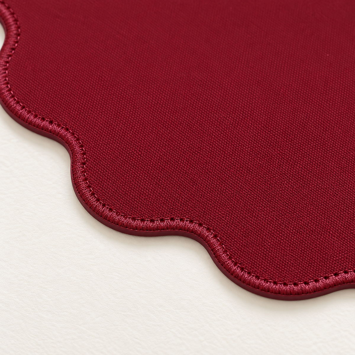 Close-up of matching burgundy stitching on the Velvet Wave desk mat